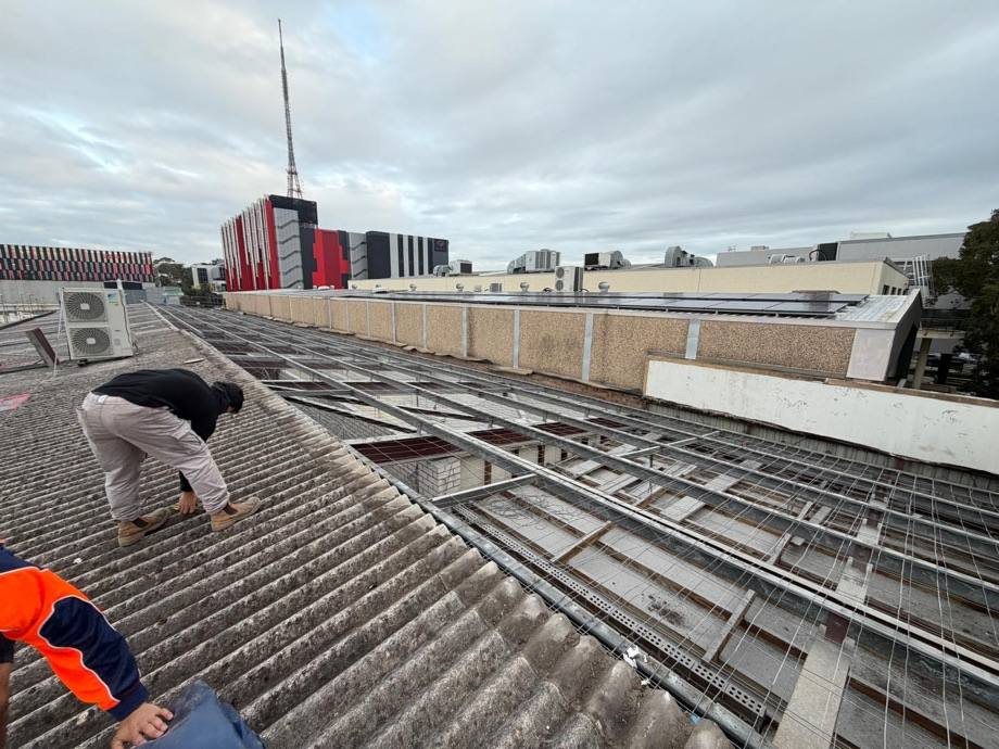 HazWreck crew member removing bonded asbestos roof sheeting by hand in Artarmon