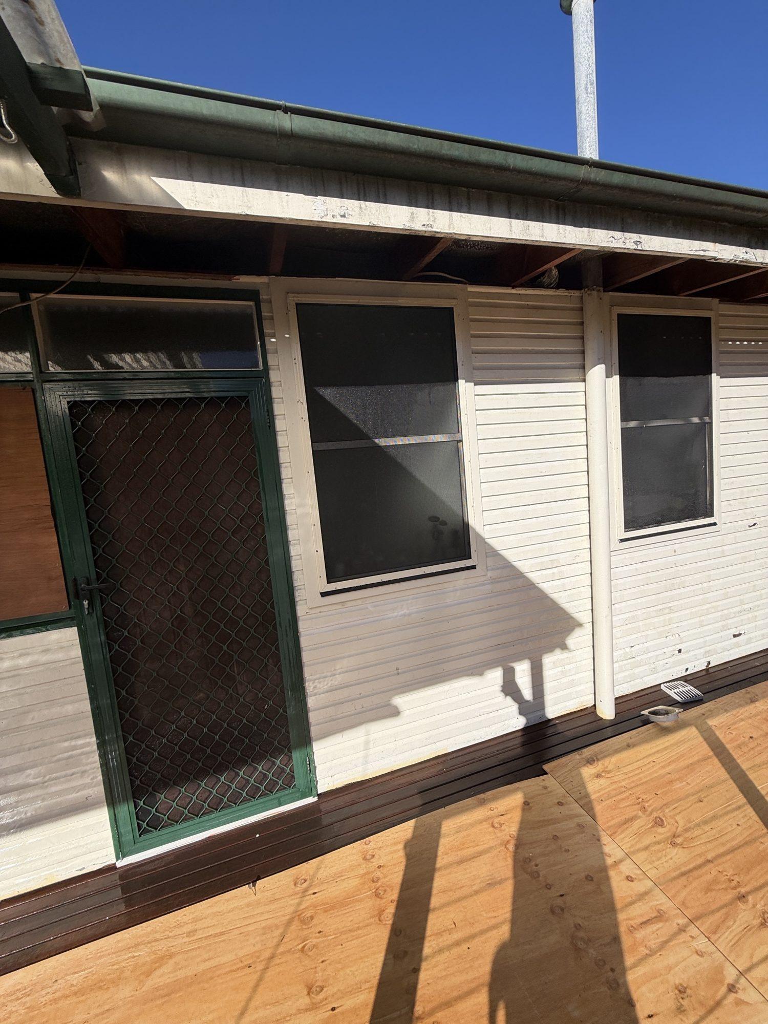 Clean timber deck and fibro wall after the asbestos eaves were removed and the site cleared