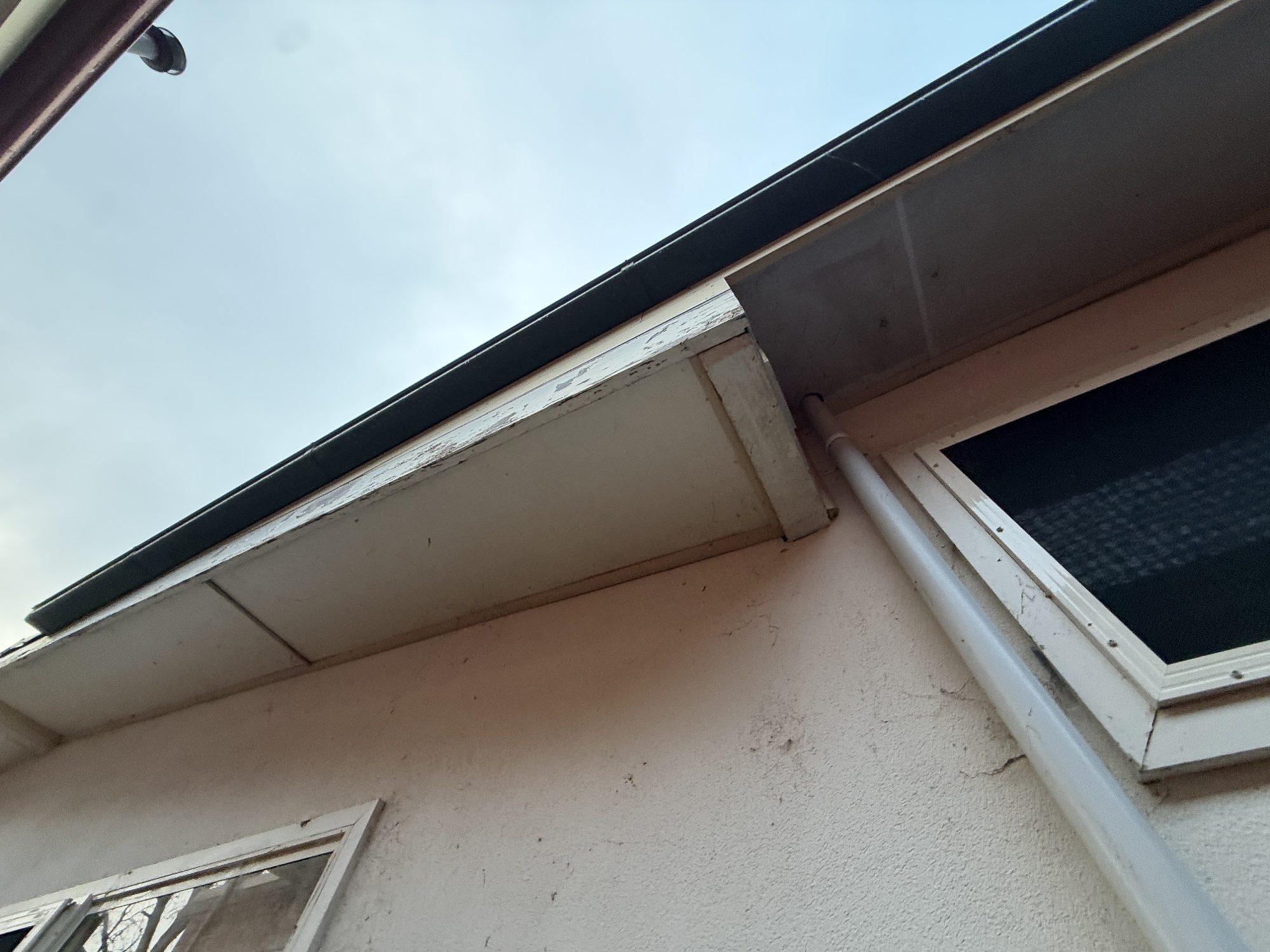 Corner of the asbestos eaves where the soffit meets the gutter and fascia