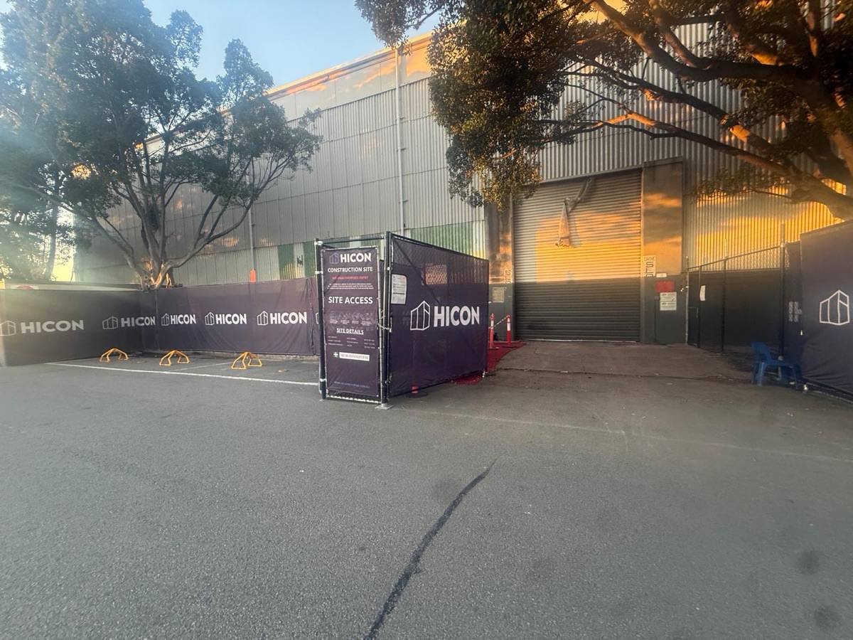 Temporary hoarding and chain-wire fencing around the Hangar 3 site entry at Sydney Airport before removal