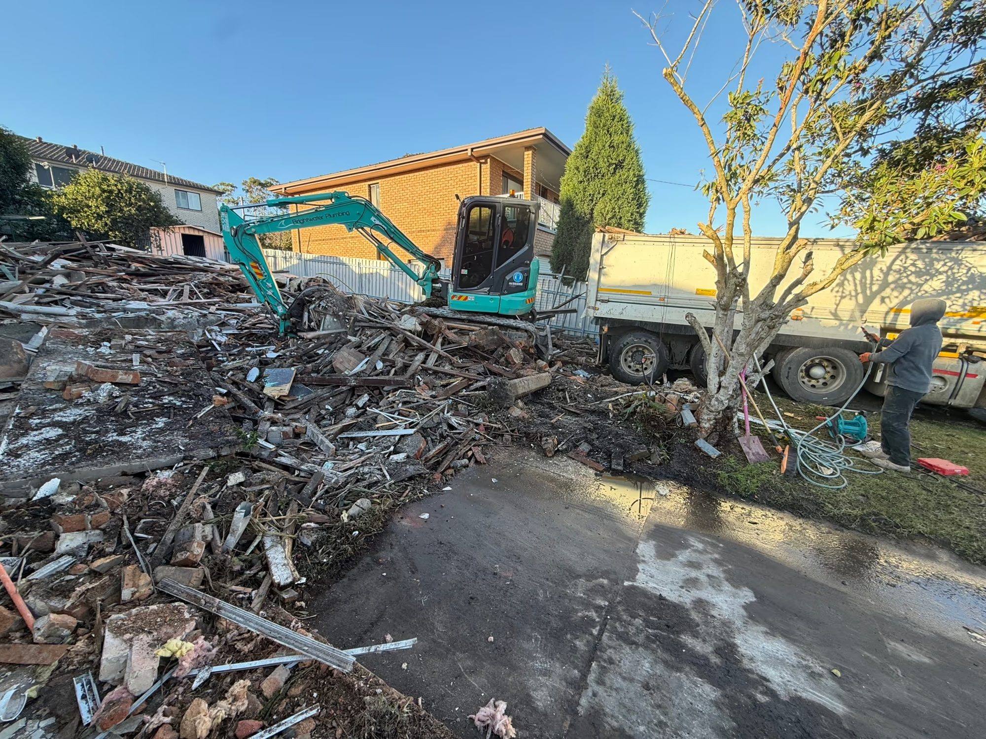 HazWreck excavator working through a demolished house on a knockdown job