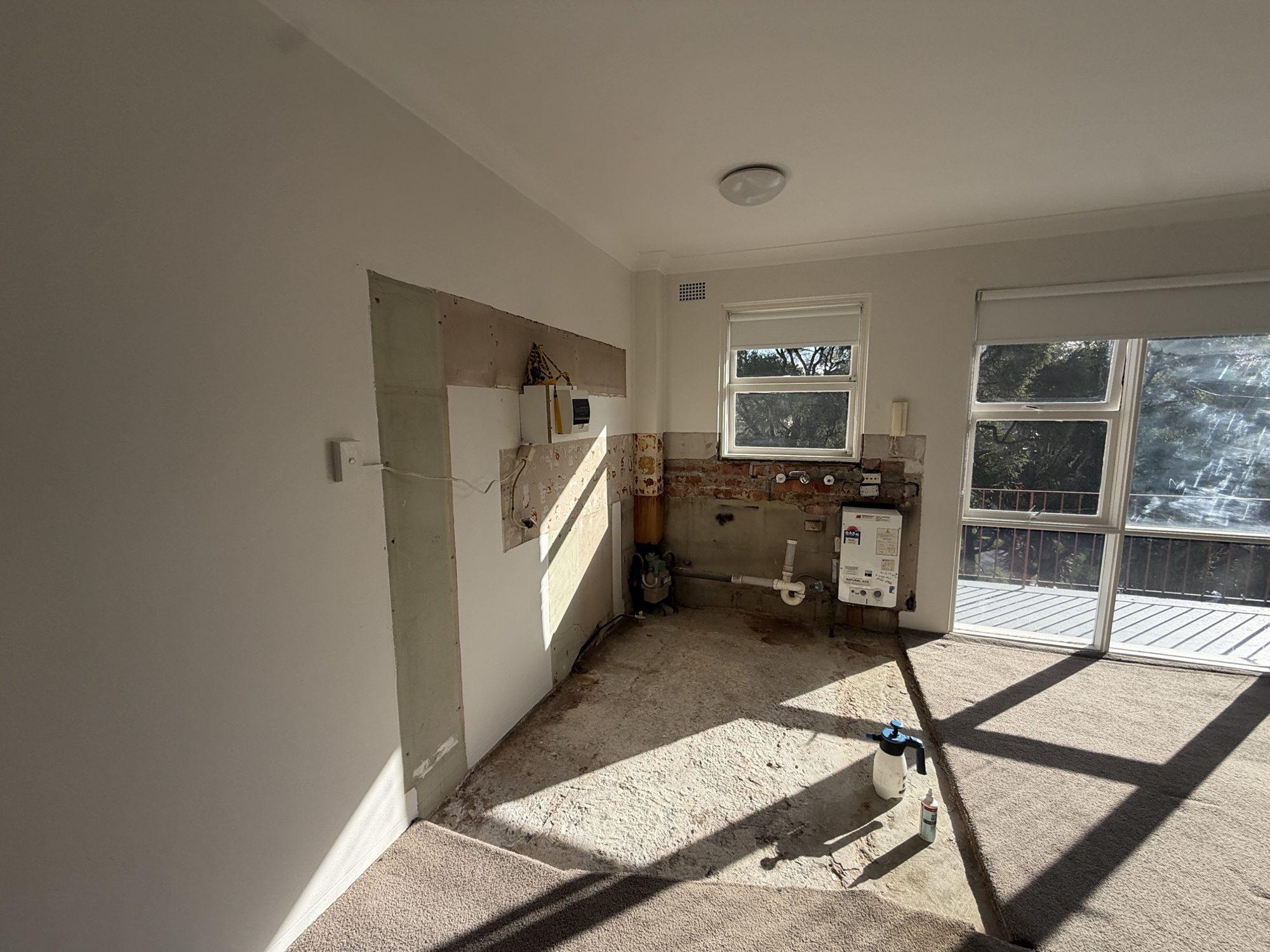 Stripped and cleaned apartment kitchen with bare walls and slab, ready for the renovation