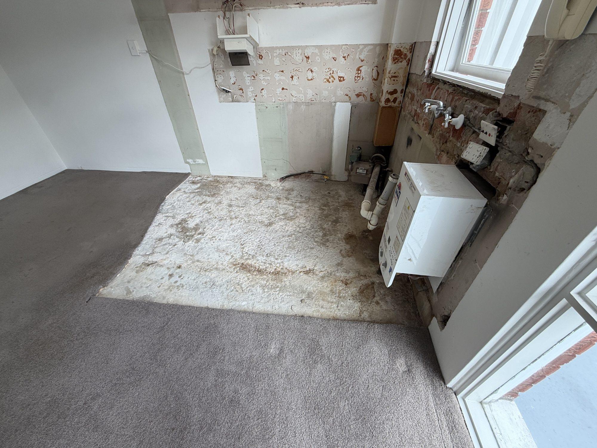 Concrete slab with adhesive residue scraped back after the asbestos vinyl was removed