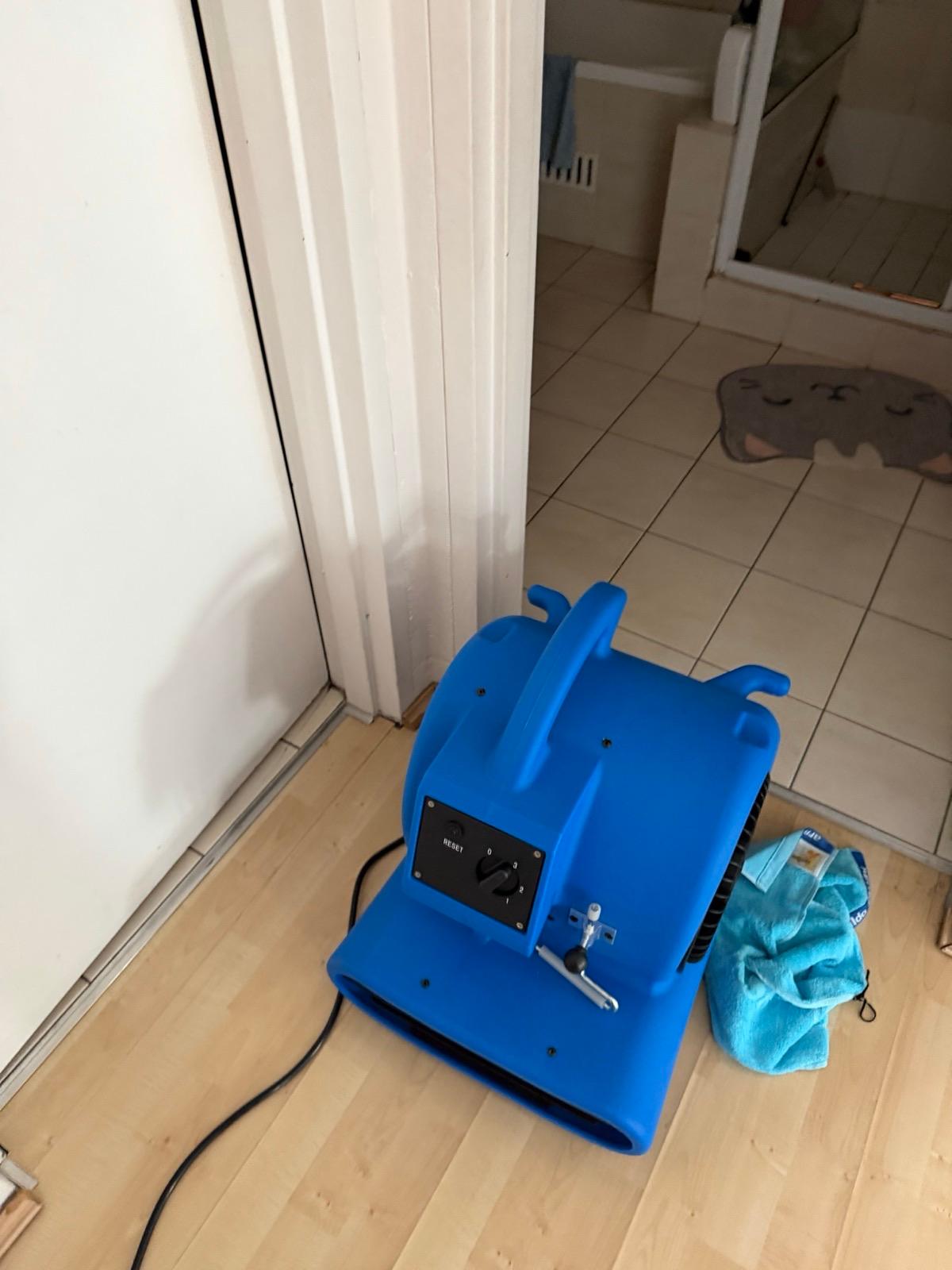 Air mover running at a doorway while a water-damaged unit dries