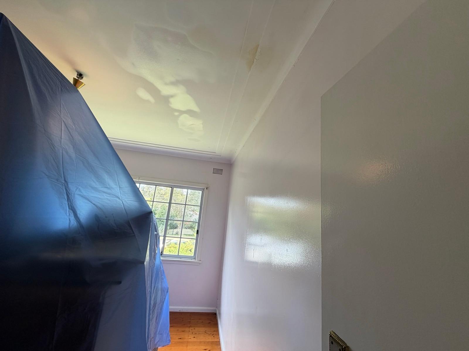 Furniture wrapped in containment sheeting during a mould remediation in a Sydney home