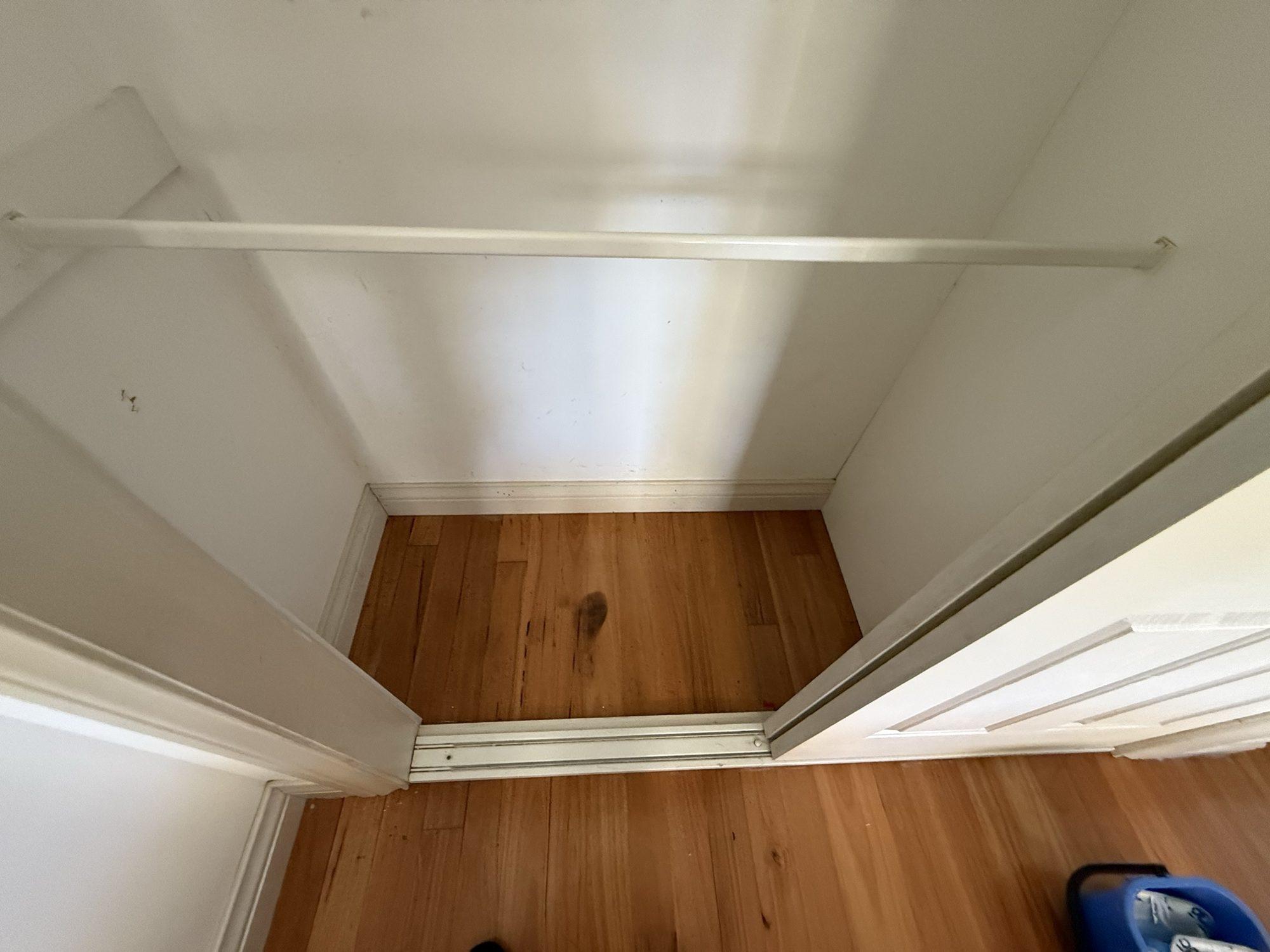 Built-in wardrobe emptied to the bare floorboards for mould treatment