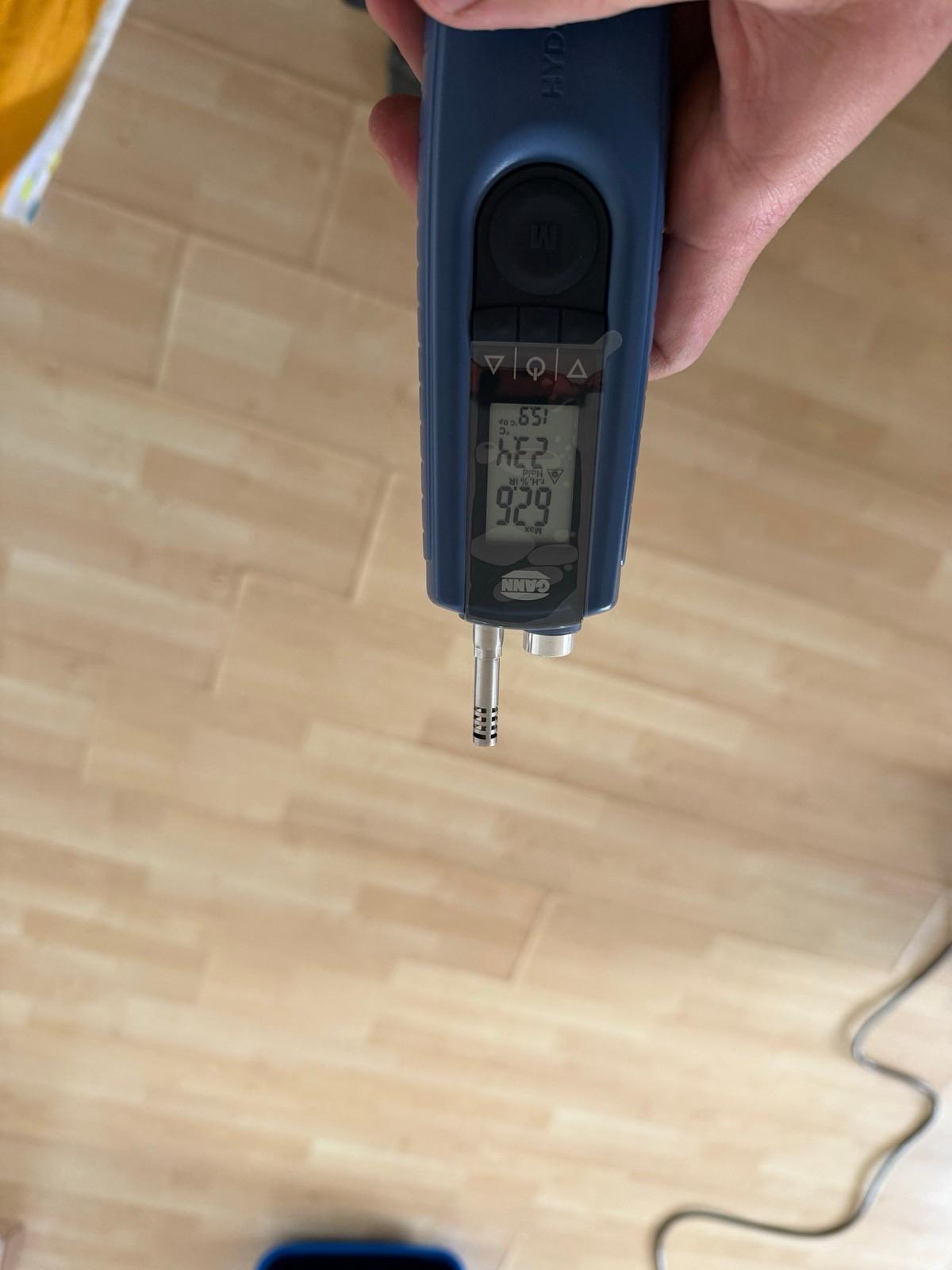 Pin moisture meter pressed into a laminate floor in a Ryde unit