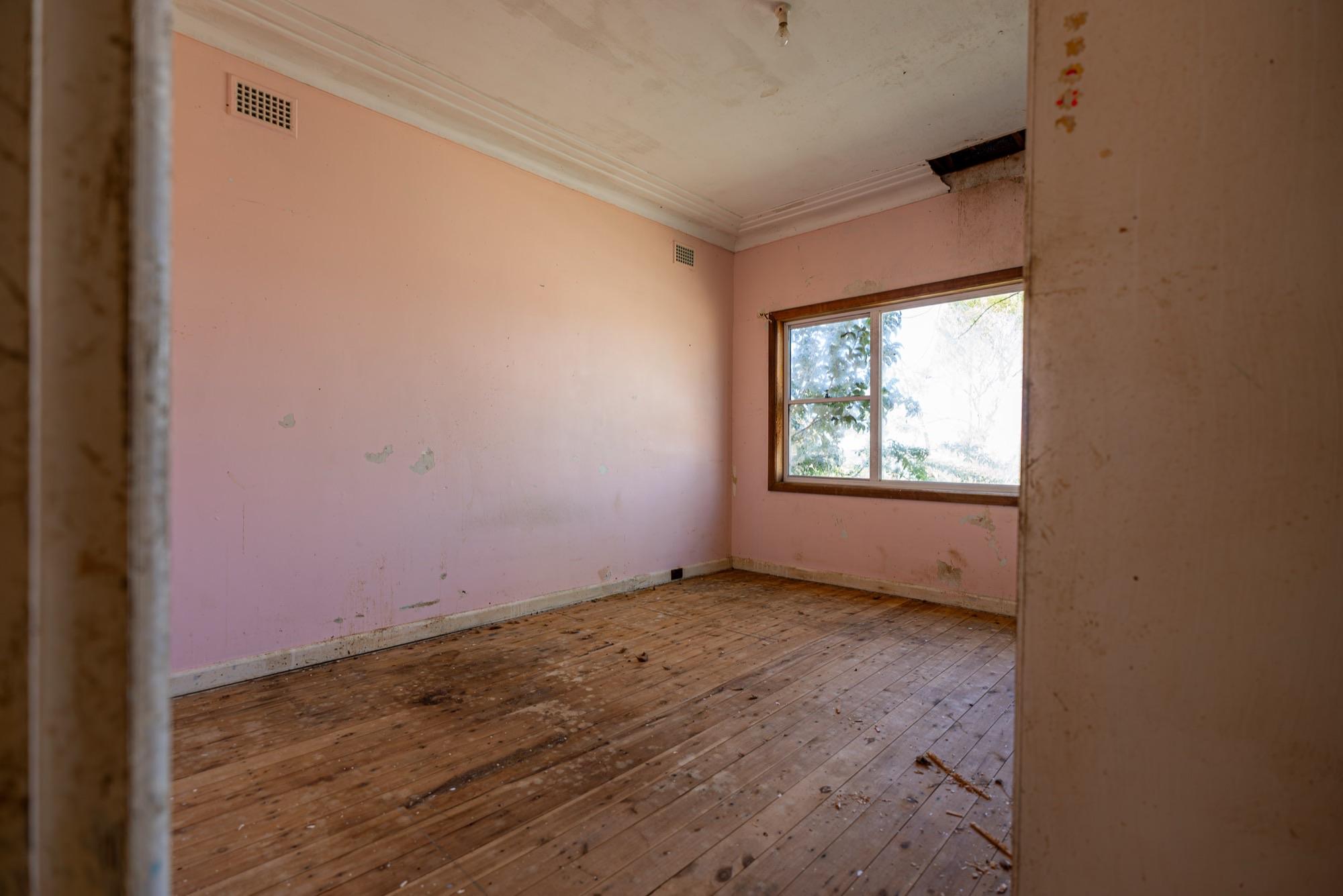Water-stained ceiling and cornice in a Sydney bedroom — the damage that runs behind the paint