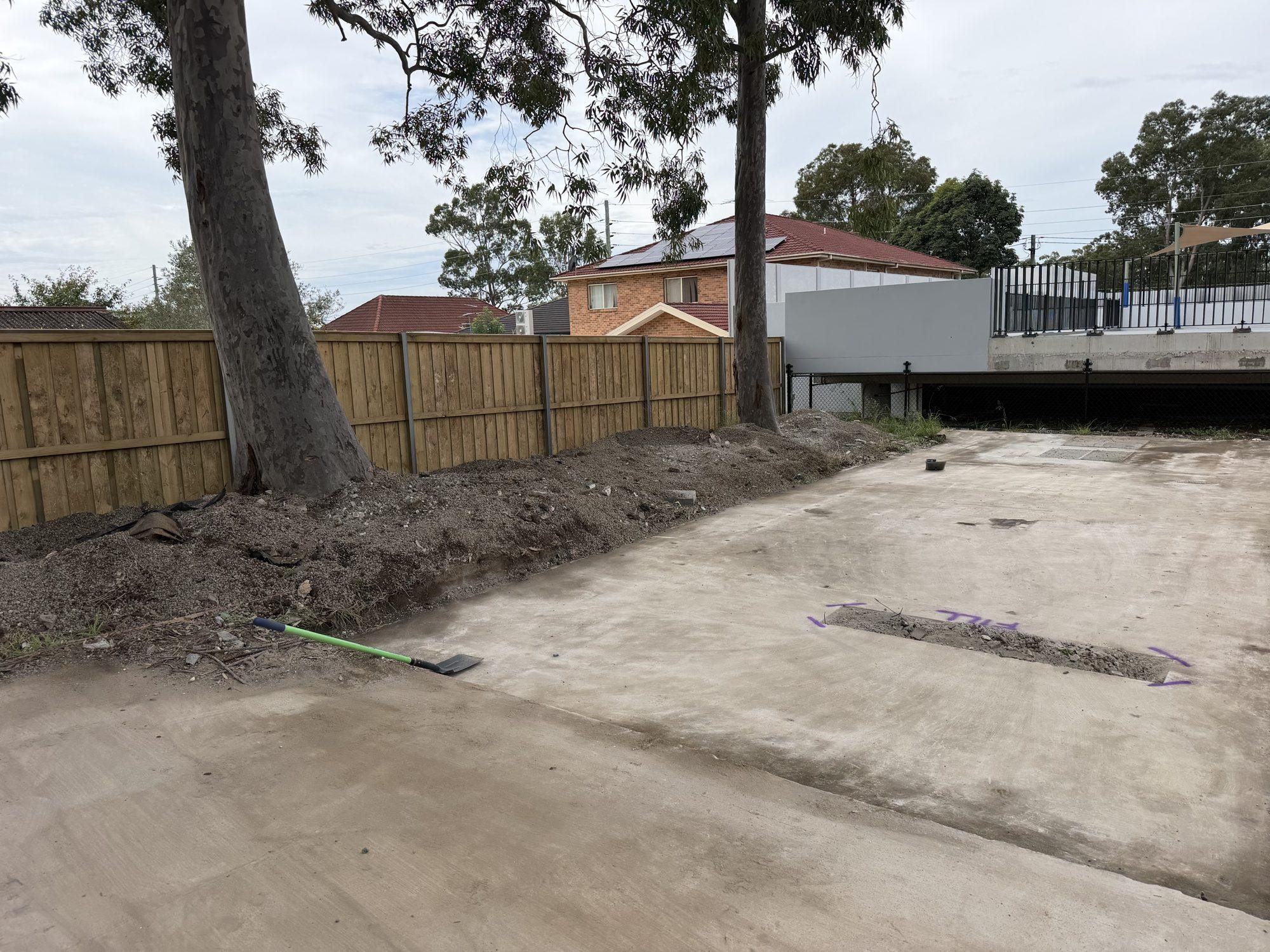 The cleared ground along the fence line after the planter beds were demolished and carted away