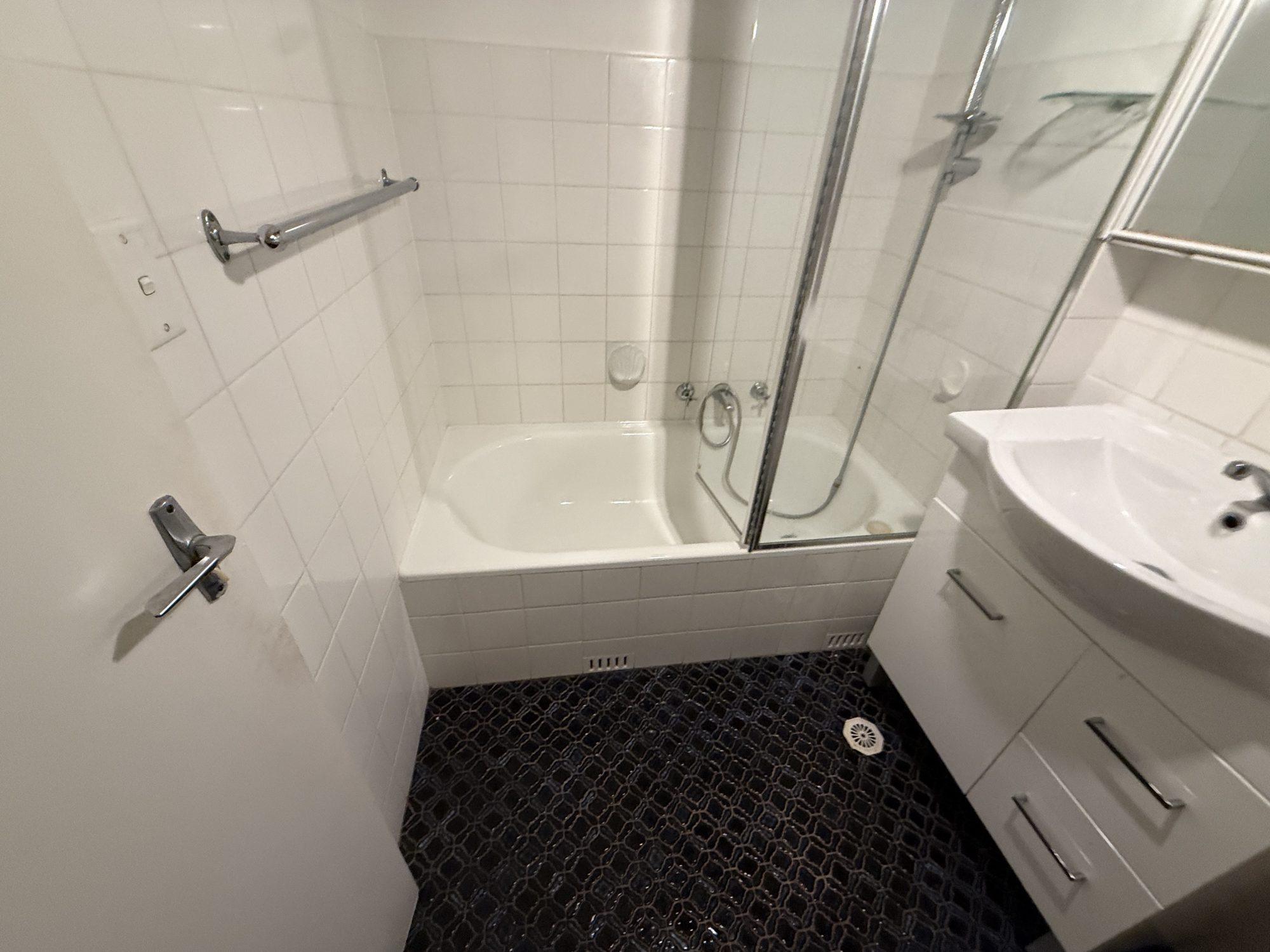 Clean white apartment bathroom after asbestos ceiling panel removal