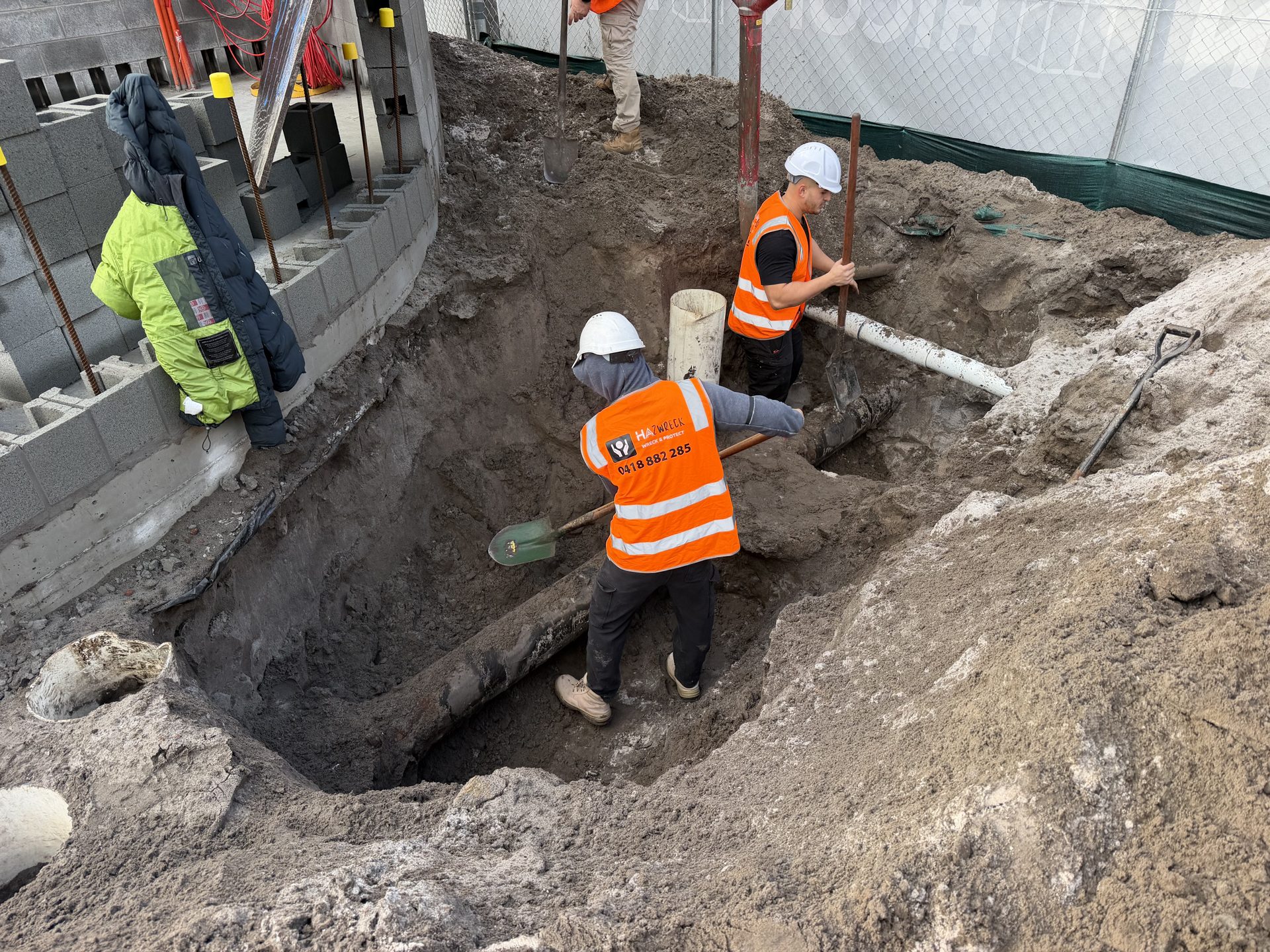 HazWreck crew working in the excavation around a buried asbestos-coated water main at a Sydney Airport precinct site