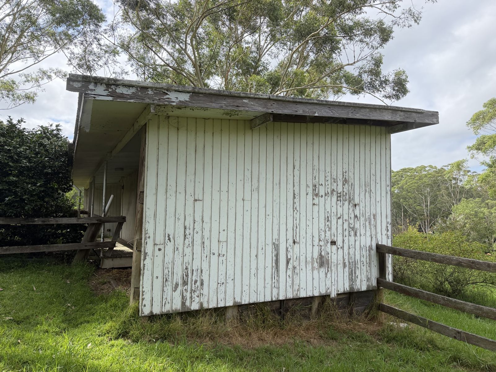 Long timber shed with a Super Six asbestos-cement roof on a rural block in Dural, photographed at the January inspection