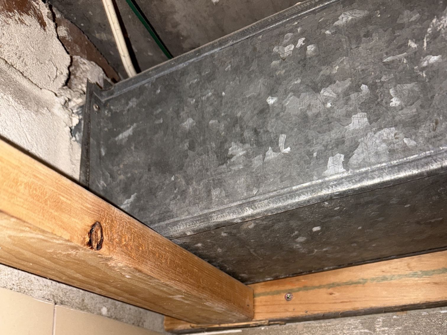 Galvanised fire damper duct exposed above the timber ceiling frame after an asbestos-cement panel was removed in an Elizabeth Bay apartment bathroom